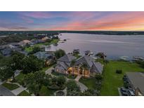 Stunning lakefront home with lush landscaping, private dock, and panoramic sunset views at 2937 Butler Bay N Dr, Windermere, FL 34786