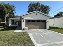 Newly renovated single-Gathering home with a freshly painted exterior, a new driveway, and well-maintained landscaping at 320 W Necho Ave, Lake Alfred, FL 33850
