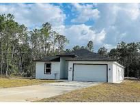 Charming single Gathering home showcasing a well-manicured lawn and an attached two-car garage at 3431 Orchid Dr, Indian Lake Estates, FL 33855