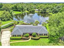 Stunning waterfront home with lush landscaping, mature trees and serene lake views at 400 Timbercove Pl, Longwood, FL 32779