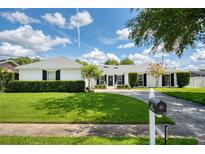 Charming front exterior featuring a green yard, a brick house, and black shutters at 417 Monticello Dr, Altamonte Springs, FL 32701