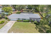 Charming home featuring a spacious front yard, mature landscaping, and a screened-in pool area at 419 W Orange St, Altamonte Springs, FL 32714