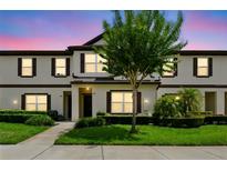 Inviting townhome exterior features well-manicured lawn and a charming tree in the front yard at 600 Northern Way # 607, Winter Springs, FL 32708