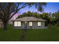 Charming single-story home with a well-maintained lawn and mature trees at 105 N Florida Ave, Howey In The Hills, FL 34737