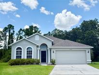 Beautiful single-story home with manicured lawn, arched windows, and two-car garage at 14700 Chadbury Ct, Orlando, FL 32828