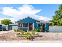 Charming blue home featuring a cozy front porch, manicured landscaping, and a welcoming entrance at 1609 E Kaley Ave, Orlando, FL 32806