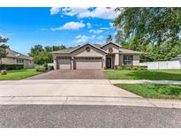 Charming single-story home featuring a three-car garage and well-manicured landscaping at 1692 Blue Grass Blvd, Deland, FL 32724