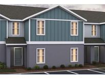 New two story townhome displaying board and batten details, gray paint and a covered entry in a manicured lawn at 2416 Cabinwood Range Way, Eustis, FL 32726