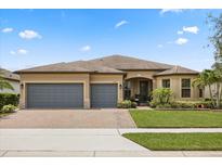 Charming one-story home featuring a three-car garage, brick driveway and meticulously landscaped front yard at 2896 Matera Dr, St Cloud, FL 34771