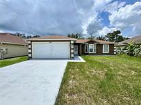 Inviting single-Gathering home featuring a clean white garage door and neutral earth tone color palette at 306 Snook Way, Kissimmee, FL 34759