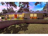 Charming brick home with a well-maintained front yard, colorful evening skies, and a beautiful landscape at 446 Alberta Dr, Winter Park, FL 32789