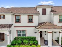 Charming two-story townhome featuring a red tile roof and well-maintained front landscaping at 4802 Lullaby Ln, Kissimmee, FL 34746