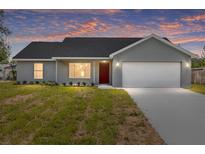 Charming single-story home featuring a two-car garage, neat landscaping, and a freshly painted exterior at 654 Ne 130Th Ct, Silver Springs, FL 34488