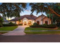 Elegant home featuring a red tile roof, lush landscaping, and a circular driveway at 9142 Southern Breeze Dr, Orlando, FL 32836