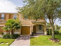 Charming two-story townhome featuring a one car garage, well maintained lawn, and mature trees at 11081 Savannah Landing Cir, Orlando, FL 32832
