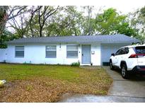 Charming single-story home with a gray roof, a white exterior, a well-manicured lawn, and a parked car at 1211 Phillip St, Winter Springs, FL 32708