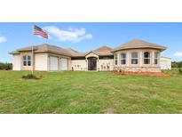 Stunning single-story home with attached garages and lush green lawn at 13023 Sweet Hill Rd, Polk City, FL 33868