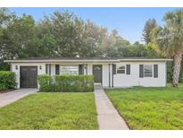 Charming single-story home featuring a well-maintained lawn, dark shutters, and an attached garage at 1320 E Lombardy Dr, Deltona, FL 32725