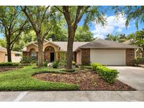 Charming brick home featuring a well-manicured lawn and mature trees, offering great curb appeal at 1453 Maple Leaf Ln, Deland, FL 32724