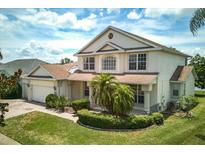 Charming two-story home featuring a well-maintained lawn, lush landscaping, and a brick-paved driveway at 2512 Chapala Dr, Kissimmee, FL 34746