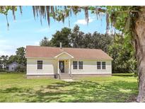 Charming single-story home with a neatly manicured lawn and cozy front porch at 28 N Osceola Ave, Center Hill, FL 33514