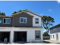 New construction townhome showcasing a two-tone paint scheme, garage and new windows at 4240 Campsite Loop, Orlando, FL 32824