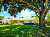 Charming single-story home featuring a well-manicured lawn, mature trees, and a classic facade with a cozy entryway at 5096 The Oaks Cir, Orlando, FL 32809