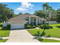 Charming single-story home featuring manicured landscaping, neutral paint, and an attached two-car garage at 7819 Canyon Lake Cir, Orlando, FL 32835