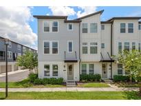 Attractive townhouse featuring a modern facade, well-maintained lawn, and professionally landscaped front yard at 8484 Sperry St, Orlando, FL 32827