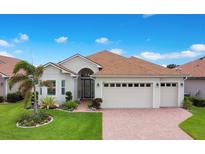 Charming single-story home with well-manicured lawn, mature landscaping, and a three-car garage at 1104 Sawgrass Dr, Winter Haven, FL 33884