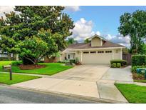 Charming single-story home with a lush front yard and long driveway leading to an attached two car garage at 1165 Baltic Ln, Winter Springs, FL 32708