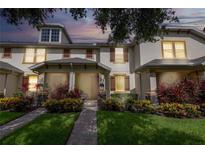 Charming townhome featuring a well-maintained lawn and colorful landscaping, perfect for a welcoming curb appeal at 14128 Avenue Of The Grvs, Winter Garden, FL 34787