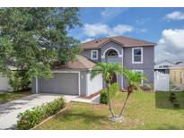 Two-story home with landscaped lawn and attached two-car garage at 16053 Wilkinson Dr, Clermont, FL 34714