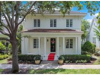 Charming two-story home featuring red tile roof, classic white pillars, and manicured landscaping at 1636 Hanks Ave, Orlando, FL 32814