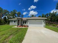 Charming single-story home with a two-car garage, manicured lawn, and freshly painted exterior at 16832 Sw 41St Avenue Rd, Ocala, FL 34473