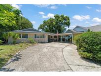 Charming single-story home featuring a brick facade, long driveway, and a covered carport at 1924 Summerfield Rd, Winter Park, FL 32792