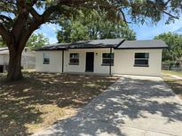 Charming white home featuring a concrete driveway and a spacious front yard shaded by a large tree at 212 Dorothy St, Auburndale, FL 33823