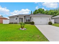 Charming single-story home featuring a well-manicured lawn and an attached two-car garage at 308 Clearwater Ln, Poinciana, FL 34759