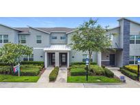 Modern townhome exterior with manicured landscaping, showcasing a stylish and inviting facade with ample parking at 850 Pebble Beach Dr, Davenport, FL 33896