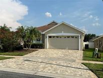 Charming single-story home with a well-manicured lawn and a paver driveway at 9003 Pecky Cypress Way, Orlando, FL 32836