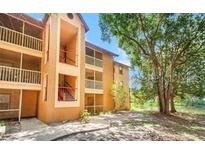 Condo exterior with balconies and stairs, set by a lake and trees at 958 Salt Pond Pl # 103, Altamonte Springs, FL 32714