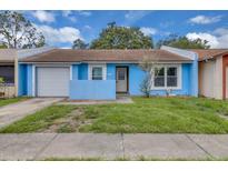 Charming single-Gathering home featuring a light blue exterior, attached garage, and a cozy front yard at 978 Calanda Ave, Orlando, FL 32807