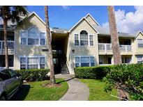 Inviting condo building featuring manicured landscaping, a stairway, and a well-maintained facade under a bright sky at 1031 S Hiawassee Rd # 2514, Orlando, FL 32835