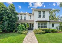 Beautiful two-story home with manicured lawn, lush landscaping, and a welcoming brick walkway at 1341 Place Picardy, Winter Park, FL 32789