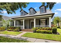 Charming home with inviting front porch, lush landscaping, and classic architectural details at 3363 Morelyn Crest Cir, Orlando, FL 32828