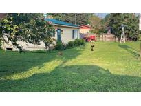 Charming single story home with lush front yard, vintage tractor, and windmill at 3691 E County Road 466, Oxford, FL 34484