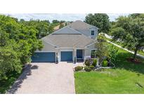 Stunning two-story home featuring a three-car garage, well-manicured lawn, and beautiful landscaping at 3994 Knott Dr, Apopka, FL 32712