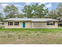 Charming home featuring a bright blue front door, geometric design and mature trees in the front yard at 4085 Cypress Bend, Geneva, FL 32732