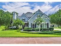 Charming single-Gathering home featuring a stone chimney and a well-manicured lawn and garden at 413 Harbour Oaks Pointe Dr, Edgewood, FL 32809