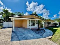 Charming single-story home featuring a covered carport, landscaped front yard, and a welcoming walkway at 435 Andes Ave, Orlando, FL 32807